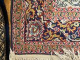 an image of a rug on a wooden floor with a cat sleeping on top of it