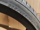 a close up of a tire on a tile floor with a wall in the background