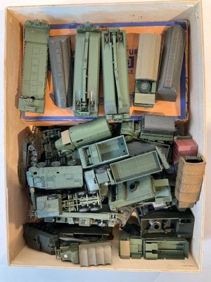 une boîte remplie de véhicules militaires miniatures et d'autres objets
