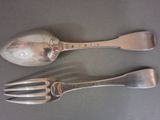 two spoons and a fork sitting on a table