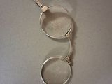 a pair of glasses sitting on a table with a keychain