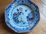 a blue and white plate sitting on a wooden floor