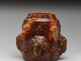 une image représentant un vase marron orné d'une tête de lion