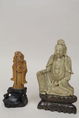 deux figurines sculptées représentant une femme et un homme assis sur un rocher