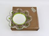 a glass bowl with a green rim on top of a brown box