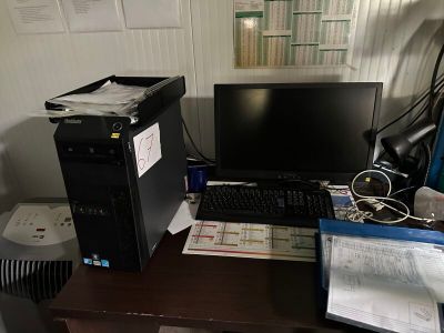 un ordinateur de bureau posé sur un bureau, à côté d'une imprimante