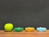 an apple sitting on top of a wooden table next to a pile of gummy gummy gummy gum
