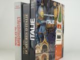 two books are stacked on top of each other on a white surface