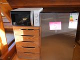 a silver refrigerator and a microwave in a small room