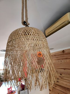 une lampe en osier suspendue au plafond dans une pièce