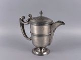 une théière ancienne en argent avec une anse, sur fond blanc
