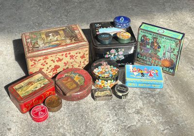 many different tins and tin cans sitting on the ground