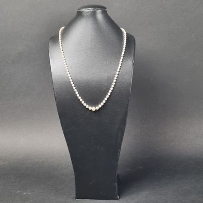 un collier de perles blanches sur un mannequin noir