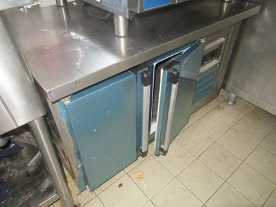 plan de travail en acier inoxydable dans une cuisine professionnelle équipée de fours