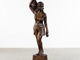 une statue en bronze représentant un homme tenant un oiseau dans la main