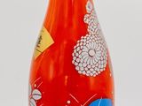 a red bottle with a blue and white design on it