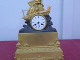 une horloge dorée posée sur une table rouge