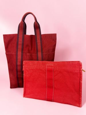 a pair of red bags sitting next to each other on a pink background