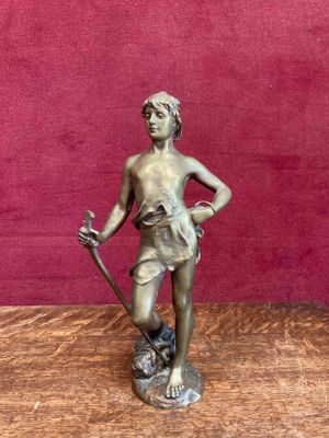 figurine en bronze représentant un garçon tenant un bâton et un chien