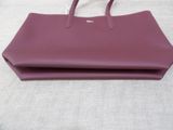 a purple handbag sitting on top of a white table