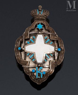 a close up of a silver broochle with a cross on it