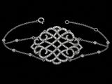 a close up of a silver bracelet with diamonds on a black background