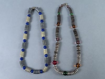 paire de colliers composés de perles multicolores sur un fond blanc