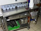 a kitchen with a stainless steel work table and pots and pans on it