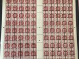 une vieille photo montrant une feuille de timbres rouges et blancs posée sur une table