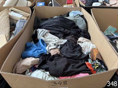 a cardboard box filled with clothes and other items
