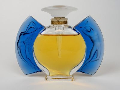un flacon de parfum posé sur une surface blanche