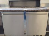 a stainless steel refrigerator with a marble counter top