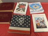 plusieurs livres posés sur une table, sur lesquels est posé un drapeau américain