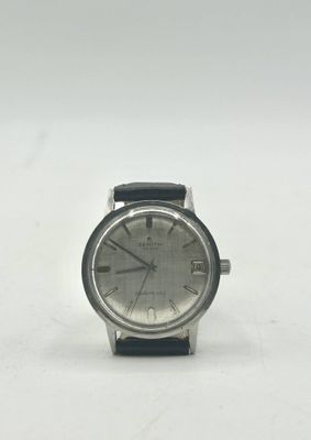 un gros plan d'une montre sur une surface blanche avec un fond blanc