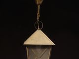an old fashioned lantern hanging from the ceiling in a dark room