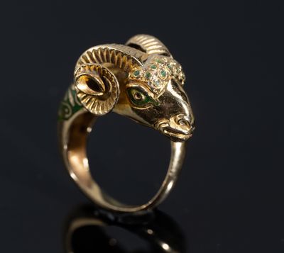 un gros plan d'une bague en or ornée d'une tête de bélier