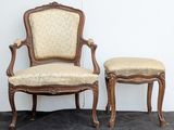 two chairs and a stool in a room with a wall in the background