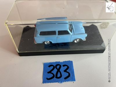 une petite voiture bleue dans une boîte transparente posée sur une table
