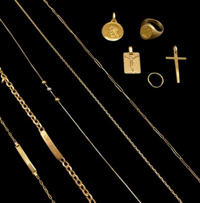 several gold necklaces, rings, and a cross on a black background