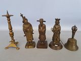 Plusieurs figurines anciennes en laiton sont alignées sur une table