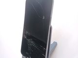 a broken cell phone sitting on a stand on a table