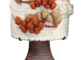 a white hat with orange and brown pom poms on it