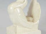 pair of white ceramic sculptures of a bird and a bird sitting on a rock