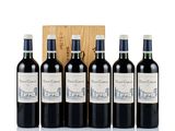four bottles of red wine in front of a wooden box