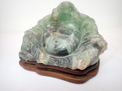 une statue représentant une personne assise sur une feuille