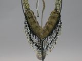 beaded necklace on a stand on a white background