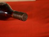 a bottle of wine sitting on a red cloth