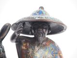 a statue of a man with a hat on holding a rabbit