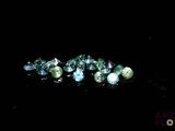 some very pretty blue and green gems on a black surface