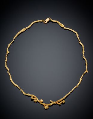 une image représentant un collier en or sur fond noir